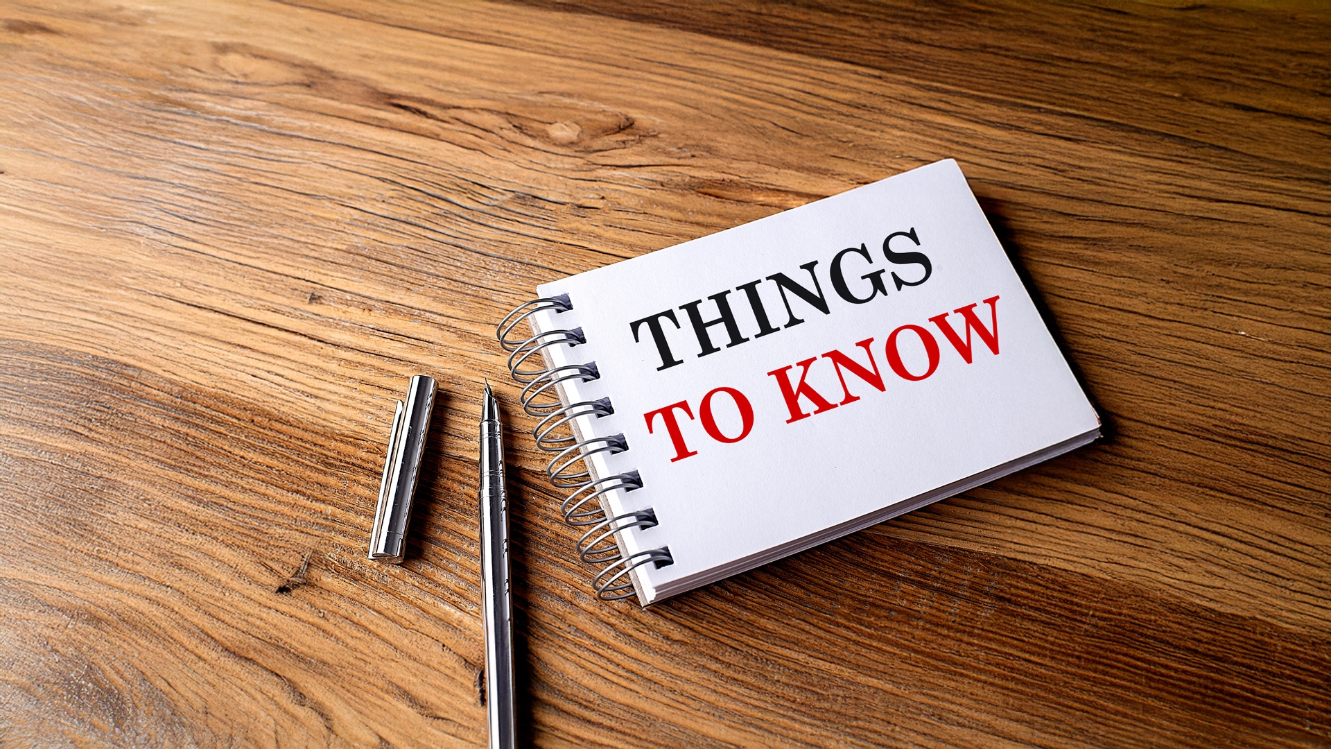 THINGS TO KNOW text on notebook with pen on wooden background